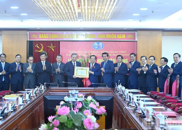 Party chief presents 45-year Party membership badge to Politburo member